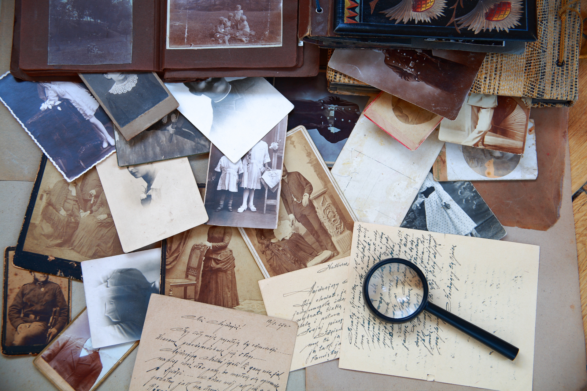 Un escritorio con muchos documentos antiguos y una lupa